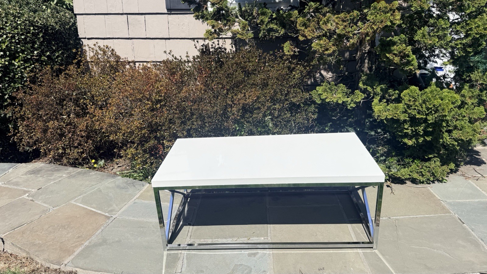 Glossy White/Chrome Base Coffee Table. 44” W X 22” D X 17” H. Good Condition.